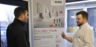 Sam Tynan discussing Rehau's Total70 product with a customer at a trade counter